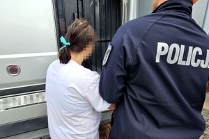 Na zdjęciu policjant i zatrzymana kobieta, którzy stoją przy samochodzie