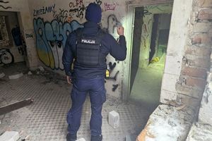 Wnętrze opuszczonego bydynku. Umundurowany policjant świeci latarką w kierunku jednego z pomieszczeń