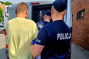 Na zdjęciu dwóch policjantów i zatrzymany mężczyzna