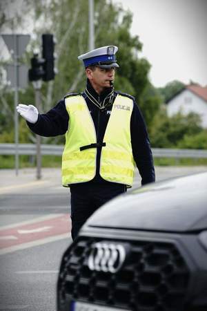 Na zdjęciu policjant ruchu drogowego, który kieruje ruchem na drodze