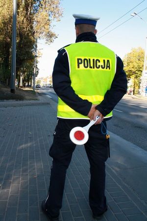 Na zdjęciu policjant ruchu drogowego, który stoi przy ulicy