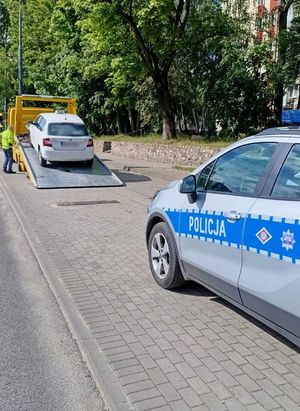 Na zdjęciu radiowóz oraz pojazd osobowy, który znajduje się na lawecie