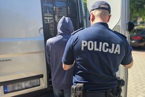 Na zdjęciu policjant, zatrzymany mężczyzna i samochód