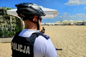 Na zdjęciu policjant obserwujący ludzi na plaży