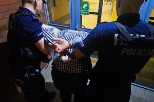 Na zdjęciu dwóch policjantów i zatrzymany mężczyzna