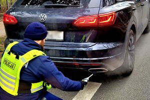 Na zdjęciu policjant i samochód