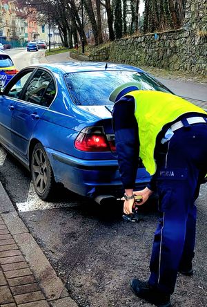 Na zdjęciu policjant i samochód