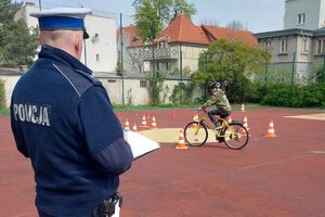 Na zdjęciu tor rowerowy, policjant i dziecko na rowerze
